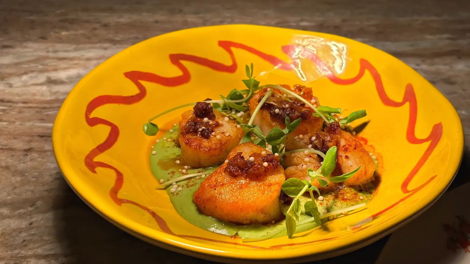 Seared scallops with herb oil and microgreens, plated by Chef Nicolás Mónaco