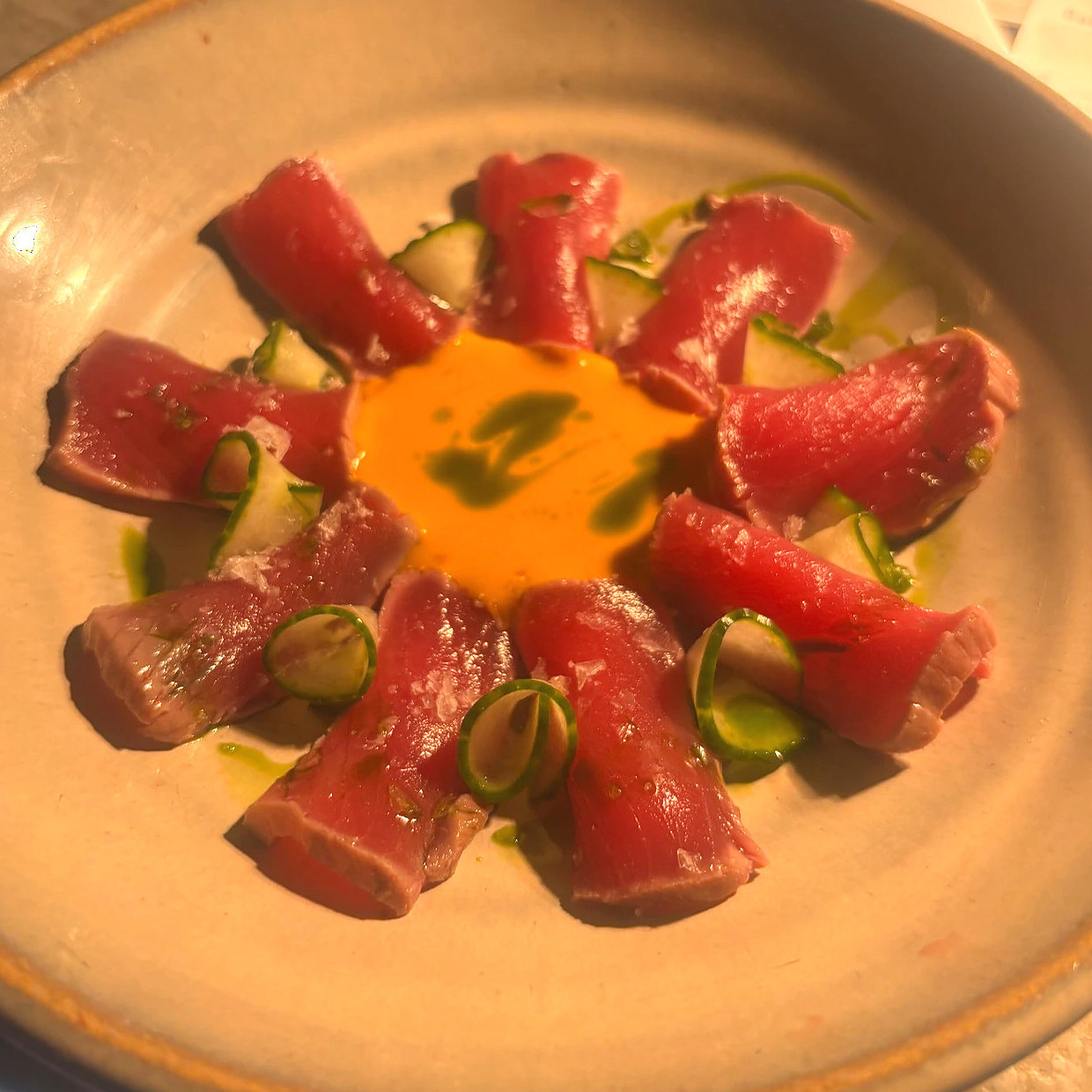Tuna crudo with citrus cream, cucumber and herb oil, plated by Chef Nicolás Mónaco