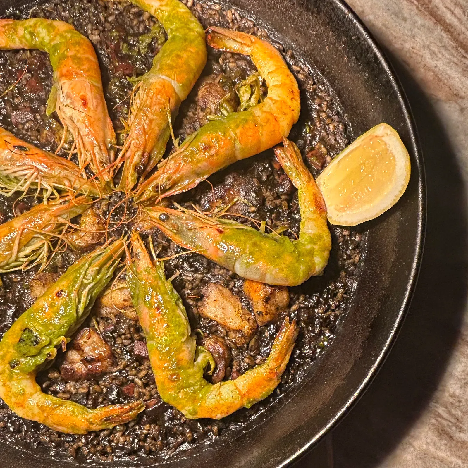 Squid-ink paella with head-on prawns, cooked over fire by Chef Nicolás Mónaco